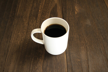木製テーブルにあるマグカップに入ったコーヒー