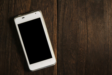 木製テーブルに置かれたスマホ