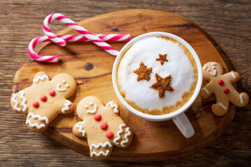 Christmas drink. Cup of cappuccino coffee with stars drawing and gingerbread cookies