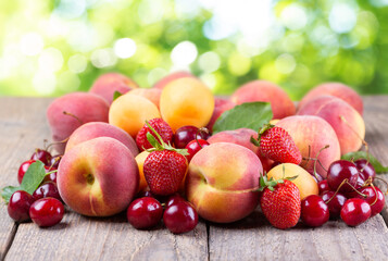 fresh fruits on a wooden table on green background