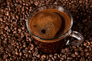 Coffee cup with freshly brewed traditional black coffee. Coffee beans in a background. Selective focus.