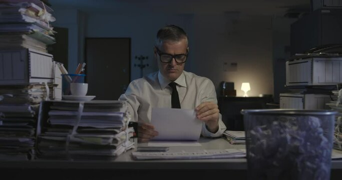 Businessman throwing paperwork in the trash can