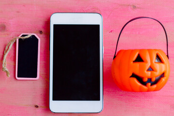 phone with pumpkin and tag on pink background background. happy Halloween