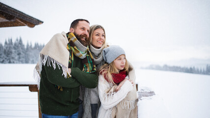 Family with small daughter on terrace outdoors, holiday in winter nature.