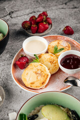 Delicious cottage cheese pancakes syrniki with jam and sour cream