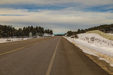 Road street street, rural roadside pine trees and snowy ground.