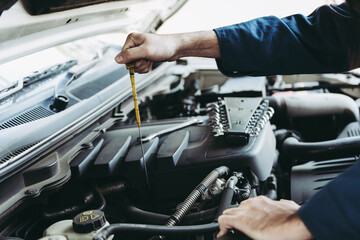 Car Repairman is Checking Engine Oil Level in Automotive Workshop, Maintenance Car Worker Inspection Checkup Oil Vehicle Engines by Dipstick Test at Automobile Shop Station. Auto Car Services
