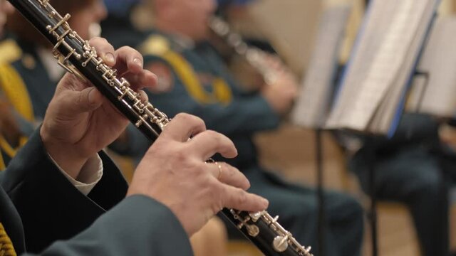 Brass military band.Hands close-up playing instruments.The orchestra is playing indoors.