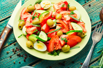 Salad with vegetables, olives, eggs and rosemary