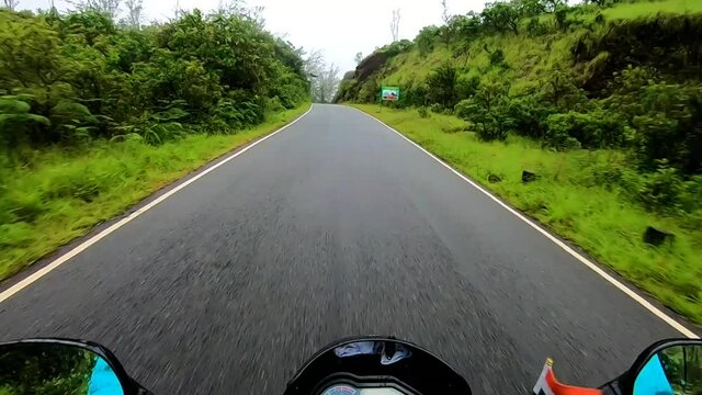 tarmac road covered with dense green forest isolated image is showing the amazing beauty. This image is taken at karnataka india.