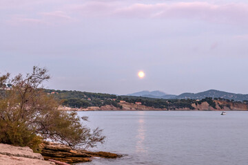 Ciel rougeoyant au moment du coucher de soleil et du lever de lune sur la mer dans le Sud de la France