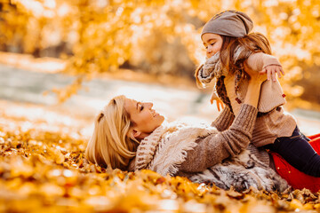 woman with her cute little daughter  in autumn park