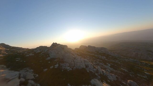 FPV video, mountain surfing, flying at high speed over a granitic mountain range during a beautiful sunrise. Mount Limbara (Monte Limbara) Tempio Pausania, Sardinia, Italy.