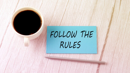 FOLLOW THE RULES text on the blue sticker with cofee and pen
