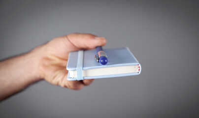 Caucasian man holding notepad and pen in office.