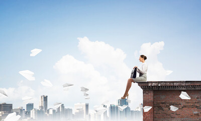 Businesswoman or accountant on building top and paper planes flying around. Mixed media