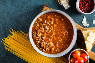 Ingredients for spaghetti bolognese on dark background. Raw pasta bolognese. Pasta flatlay. Italian bolognese. Food ingredients. Pasta top view