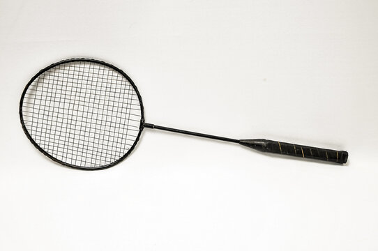 High angle closeup of a badminton racket on a white background