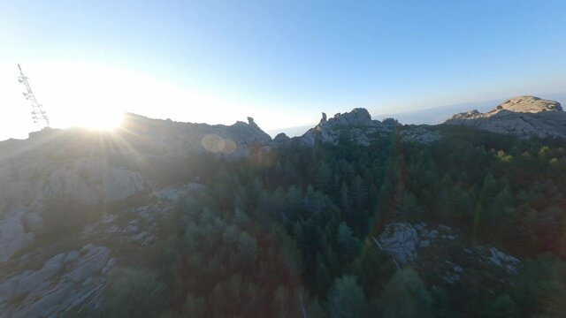 FPV video, mountain surfing, flying at high speed over a granitic mountain range during a beautiful sunrise. Mount Limbara (Monte Limbara) Tempio Pausania, Sardinia, Italy.