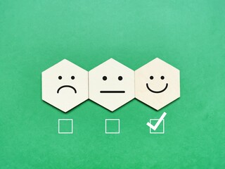 Best customer experience and excellent service concept. Wooden hexagon with emotion face.
