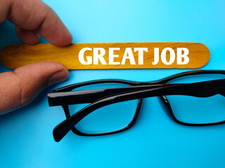 Glasses and colored ice cream stick written with text GREAT JOB on blue background.