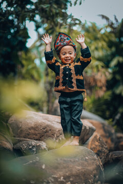 Portrait Of Smiling Boy Standing On Rock
