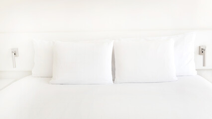 Close up of white pillows on the bedroom on a bed with duvet case bedspread isolated on white background
