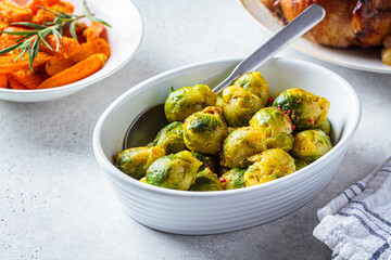 Thanksgiving Brussels sprouts in white dish on festive table.