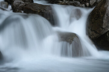 Long exposure waterfall. Mountain river in the Alps long exposure. Flowing water over rocks, motion blur. Cold, clear water in the Italian Alps. Wild mountain river in the mountains.