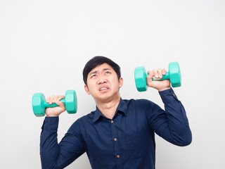 Man holding dumbbell feeling heavy and looking up at copy space