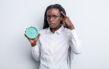 pretty black woman feeling confused and puzzled, showing you are insane. alarm clock concept