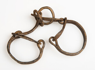 a pair of antique handcuffs on white background