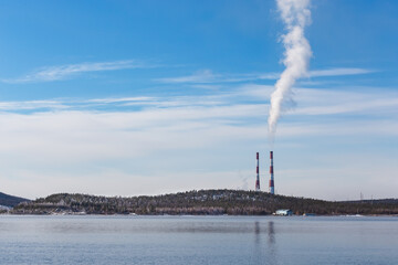 Lake shore with hills and chimneys, in autumn