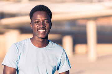 African young man smiling to the camera outdoors