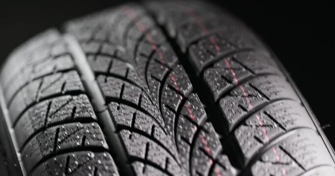 Clean car tyres spinning against dark background