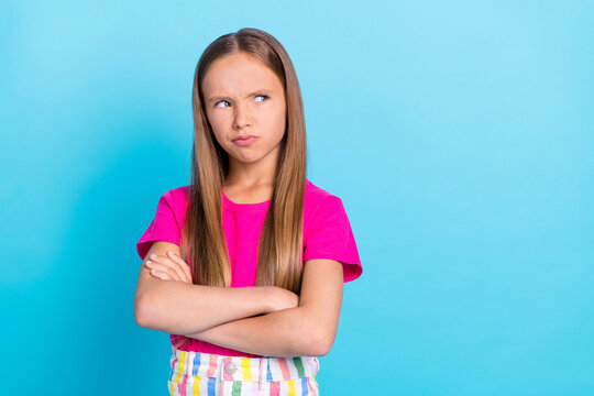 Photo of unhappy upset young offended girl look empty space hands folded isolated on blue color background