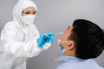 doctor with PPE suit test coronavirus(covid-19) to man by nasal swab