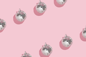 Christmas and New Year creative pattern or frame with disco ball decoration on pastel pink...