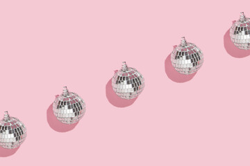 Christmas and New Year creative pattern or frame with disco ball decoration on pastel pink...
