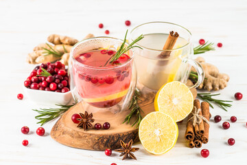 Cranberry tea and ginger tea with lemon and spices in glass mugs. Healthy hot vitamin drink.