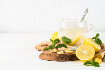 Ginger tea with lemon and mint in glass mug. Healthy hot vitamin drink.