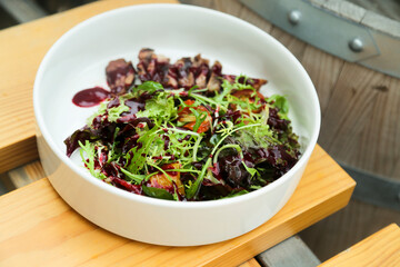 Healthy green salad with veal steak and berry sauce
