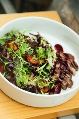 Healthy green salad with veal steak and berry sauce