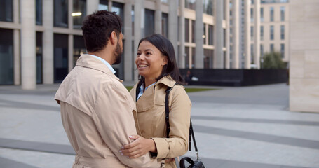 Fototapeta premium Elegant diverse couple cuddling outdoors on city street