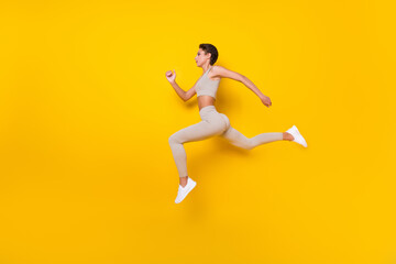 Fototapeta na wymiar Full length body size profile side view of pretty girl jumping running weight loss isolated over bright yellow color background
