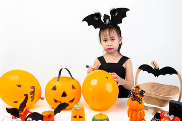 Cute girl DIY the ornament painting balloons and pumpkins, Halloween celebrating happy Thanksgiving day.