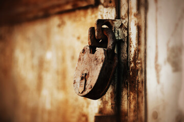 A big old vintage rusty padlock closes the old cracked abandoned gate. Closed. Secret.