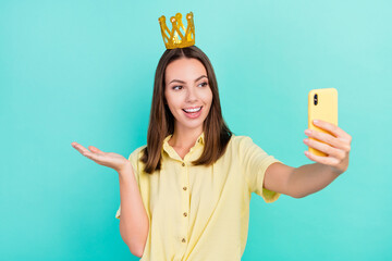 Photo of cool young brunette lady do selfie hold empty space wear tiara yellow top isolated on teal...