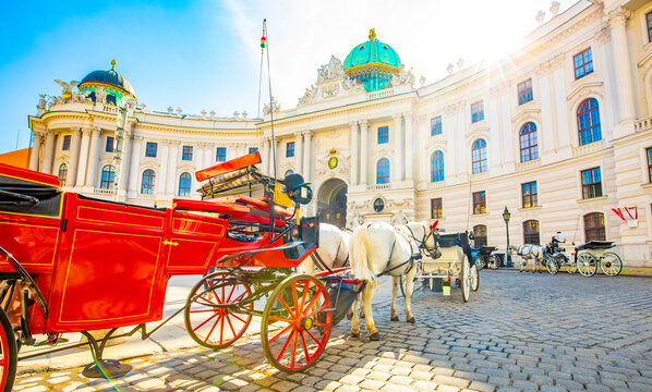 Hofburg palace and horse carriage on sunny Vienna street, Austria