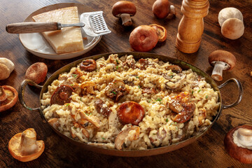 Risotto ai funghi, mushroom risotto, rustic rice with mushrooms and cheese, with ingredients, on a dark wooden background
